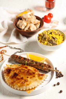 Geleneksel Doğu yemekleri ve dua boncukları beyaz masada. Ramazan kutlaması