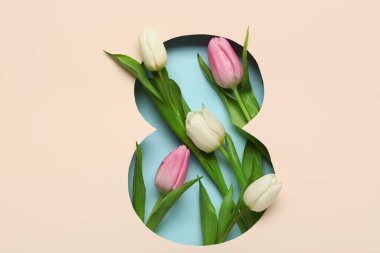 Mavi arka planda güzel laleleri olan, şekil 8 şeklinde bej bir kağıt kes. Uluslararası Kadınlar Günü