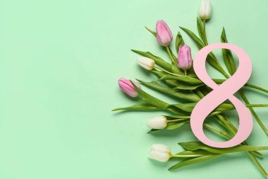 Şekil 8 kağıttan yapılmış ve yeşil arka planda güzel laleler var. Uluslararası Kadınlar Günü