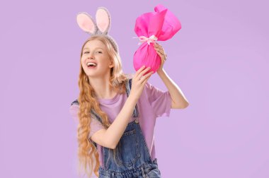 Paskalya tavşanı kulaklı ve leylak arkaplanlı genç bir kız.
