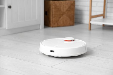 Modern robot süpürgesi oturma odasında yerde.