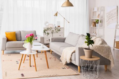 Uluslararası Kadınlar Günü için kanepeleri ve laleleri olan oturma odasının içinde.