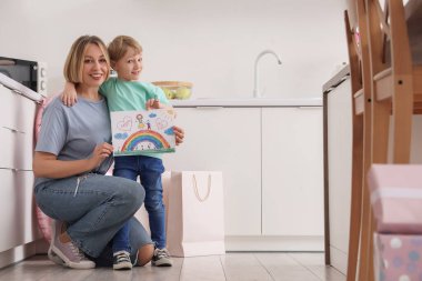 Mutfakta annesine sarılan küçük bir çocuk. Uluslararası Kadınlar Günü