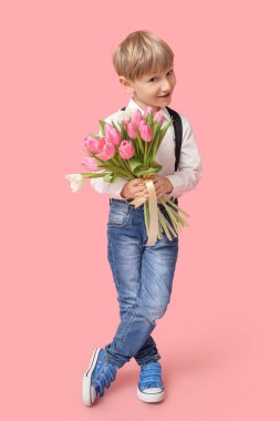 Pembe arka planda bir buket güzel lalesi olan sevimli küçük bir çocuk. Uluslararası Kadınlar Günü