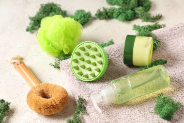 Beyaz grunge arka planda kozmetik ürünleri, havlu ve yosun içeren silikon kafa masajı fırçası