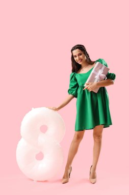 Pembe arka planda hediye ve balon şeklinde 8 figürlü güzel bir kadın. Uluslararası Kadınlar Günü