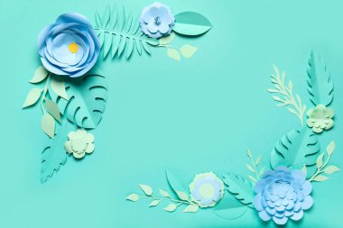 Yeşil arka planda yaprakları olan kağıt çiçeklerden yapılmış çerçeve