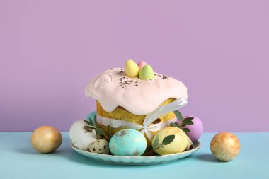 Lezzetli Paskalya pastaları ve renkli arka planda boyanmış yumurtalar içeren kompozisyon