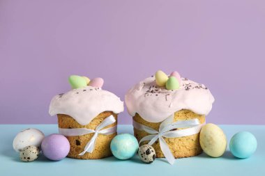 Lezzetli Paskalya pastaları ve renkli arka planda boyanmış yumurtalarla kompozisyon