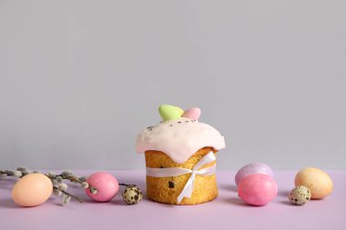 Composition with delicious Easter cake, pussy willow branch and painted eggs on color background