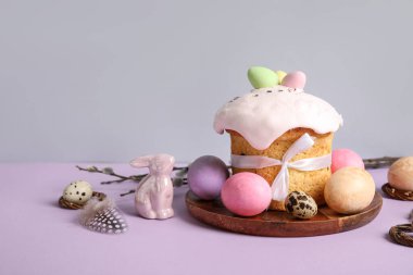Lezzetli Paskalya pastası, porselen tavşan ve ahşap tabakta renkli yumurta.