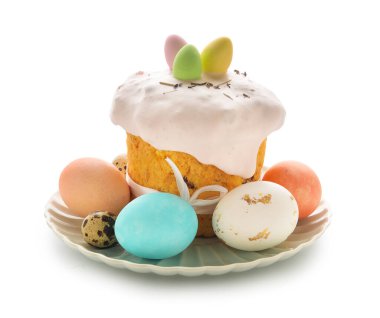 Lezzetli Paskalya pastası ve beyaz arka planda tabakta boyanmış yumurtalar.