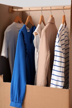 Gri arka planda giysileri olan kostüm kutusu.