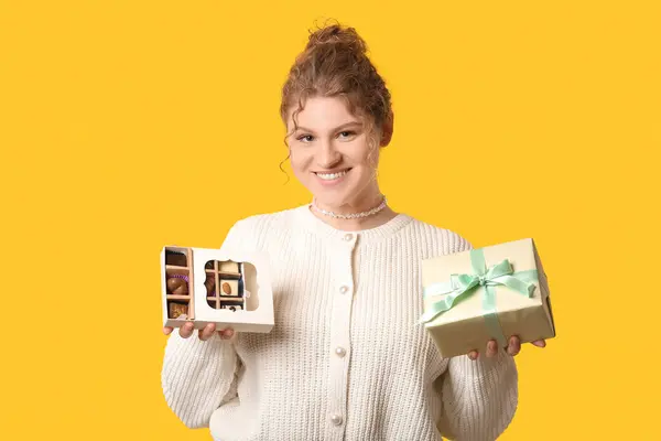 Щаслива Молода Жінка Тримає Коробку Солодкими Шоколадними Цукерками Подарунком Жовтому — стокове фото