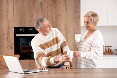 Mutfakta kahve içen olgun bir çift.