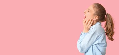 Pembe arka planda diş ağrısı çeken genç bir kadın ve mesaj için yer var.