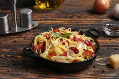 Ahşap arka planda lezzetli makarna ile kızartma tavası.