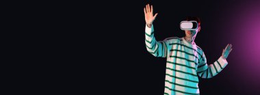 Genç adam koyu arkaplanda VR gözlük ve metin için boşluk kullanıyor