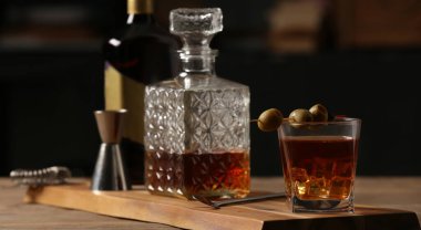 Bardakla bir şişe soğuk Kokteyl Bardaki ahşap masada