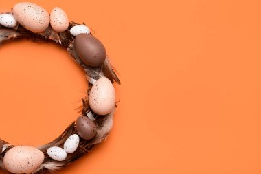 Turuncu arka planda yumurta ve tüylü Paskalya çelengi