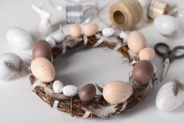 Beyaz arkaplanda Paskalya çelengi yapmak için malzeme içeren kompozisyon