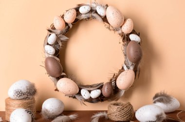 Duvarda asılı Paskalya çelengi malzemeleriyle birlikte.