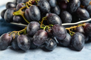 Mavi arka planda tatlı siyah üzümlü tabak