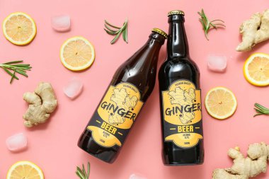 Taze zencefilli bira, biberiye, limon dilimleri ve pembe arka planda buz küpleriyle kompozisyon