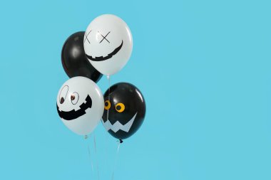 Mavi arka planda farklı Cadılar Bayramı balonları