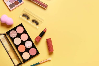 Sarı arka planda farklı dekoratif kozmetik ürünler