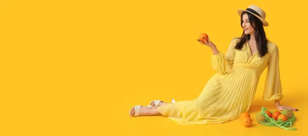 Schöne Junge Frau Stilvollem Kleid Und Orangen Auf Gelbem Hintergrund — Stockfoto