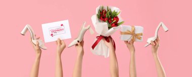 Lale buketli kadın elleri, tebrik kartı ve pembe arka planda yüksek topuklu ayakkabılar. Uluslararası Kadınlar Günü için Alışveriş