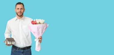 Mavi arka planda çiçekleri olan genç bir emlakçı. Uluslararası Kadınlar Günü