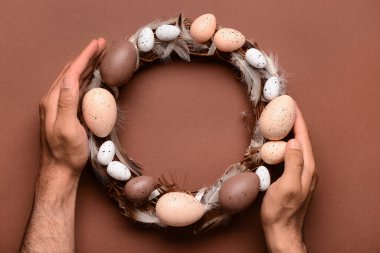 Kahverengi masada Paskalya çelengi tutan adam.