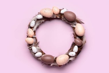 Leylak arka planında yumurta ve tüylü Paskalya çelengi