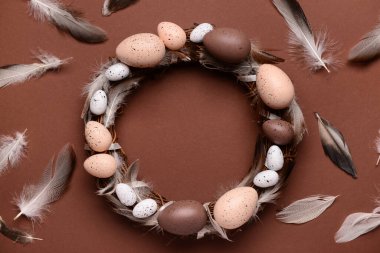 Kahverengi arka planda yumurta ve tüylü Paskalya çelengi