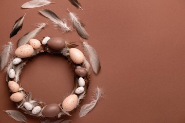 Kahverengi arka planda yumurta ve tüylü Paskalya çelengi
