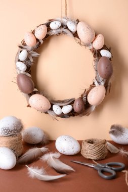 Duvarda asılı Paskalya çelengi malzemeleriyle birlikte.