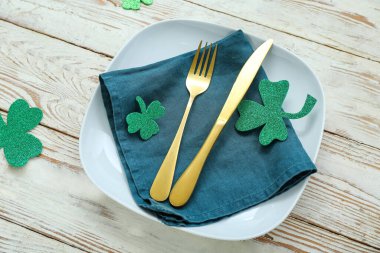 Beautiful table setting for St. Patrick's Day celebration on light wooden background