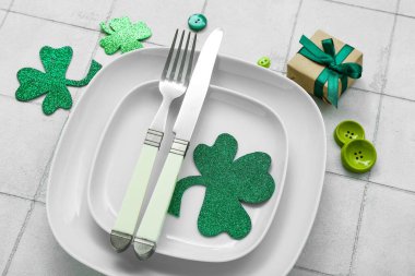 Beautiful table setting for St. Patrick's Day celebration on white tile background