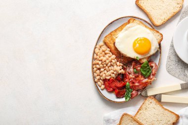 Hafif arka planda sahanda yumurtalı lezzetli İngiliz kahvaltısı.
