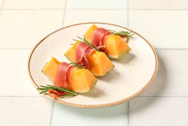 Hafif fayanslı jambonlu ve biberiyeli lezzetli kavun tabağı.