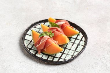 Lezzetli kavun, jambon ve fesleğen arkaplanda.