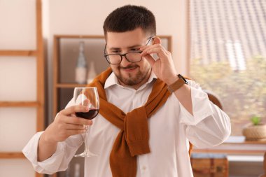 Genç şarap garsonu mutfakta bir bardak şarapla