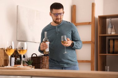 Genç şarap garsonu elinde şişe ve bir bardak şarapla evde.