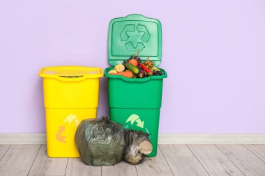 Yiyecek atıkları ve leylak duvarın yanındaki çöp torbaları için çöp kutuları. Geri dönüşüm kavramı