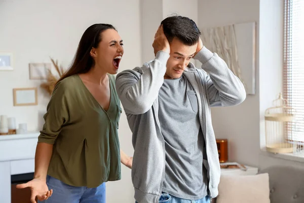 Angry young woman quarreling with her husband at home