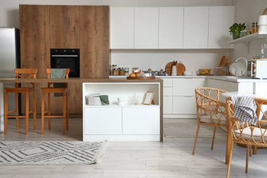 Modern mutfak, beyaz mobilyalar ve ahşap ada masası.