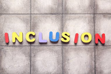 Kelime INKLÜZİON beton arka planda renkli ahşap harflerden yapılır