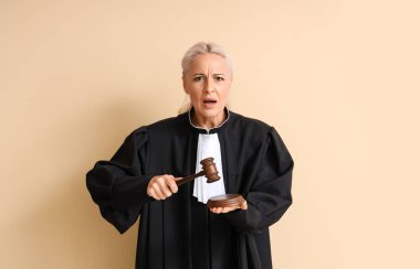 Bej arka planda tokmağı olan duygusal olgun bir yargıç.